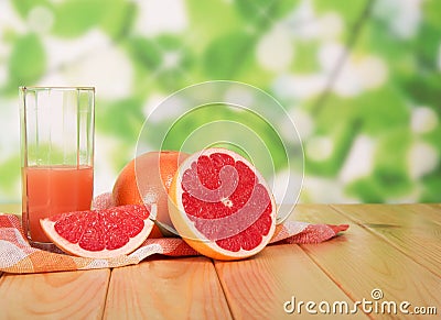 Glass of grapefruit juice and sliced â€‹â€‹on table in yard Stock Photo